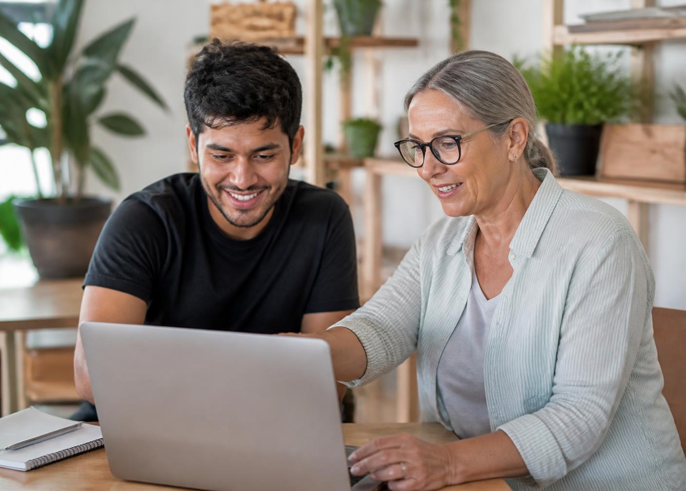 Deux apprenants souriants échangeant sur leur projet de formation devant un ordinateur